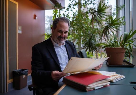 Marc Schulz smiling as he looks down at his files